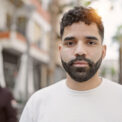 Young hispanic man standing with serious expression at street Young hispanic man standing with serious expression at street